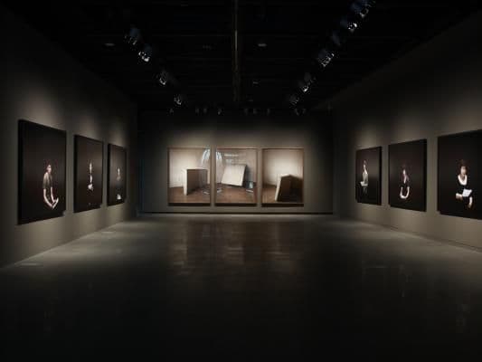 Dark gallery room with spotlit artworks